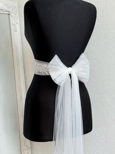 A stunning, elegant statement wedding sash is exquisitely beaded in beautiful vintage pattern. Your choice tulle  sash is attached to the beading and ties at the back into a bow.  An ultimate luxurious accent piece for your wedding dress or for any special occasion dresses. Accentuate your waist and add a touch of feminine charm to any dress with this tulle sash. Even the most simple gown can transform into a dreamy ensemble with this voluminous bow. Color embroidery - ivory or white Color tulle may be different  - white, ivory... and other Bead embroidery length 50 cm The belt is made as a long ribbon that you can tie around your waist. Elegant Bridal Belt With Satin Bow For Bridesmaid, Fitted Ribbon Sash For Wedding, Elegant Bridal Belt With Satin Bow For Wedding, Elegant Tulle Veil For Bridal Shower, Elegant White Tulle Fabric For Ceremony, Elegant Organza Bridal Accessories For Ceremony, Elegant Ribbon Bridal Belt For Wedding, Elegant White Bridal Belt With Satin Bow, Elegant Tulle Bridal Accessories For Bride