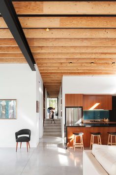 a living room filled with furniture next to a kitchen