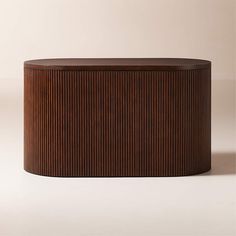 a round wooden box sitting on top of a white floor next to a brown wall