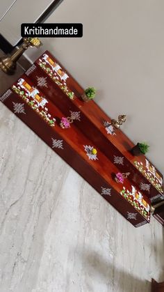 a wooden table with flowers on it in a room that has marble floors and walls