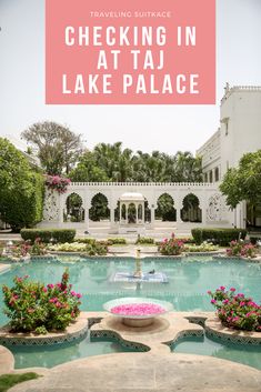 a large swimming pool surrounded by flowers and greenery with text overlay reading checking in at taj lake palace