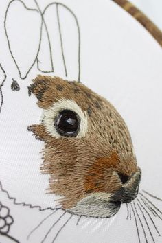 a close up of a bunny rabbit face on a white background embroideryed onto a hoop