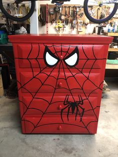 a red dresser with a spiderman face painted on it