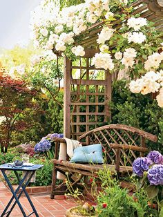 a bench sitting in the middle of a garden next to flowers and plants on either side of it