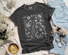 ✨ Flaunt your unique style with our aesthetic tees! This Instagram-worthy design is printed with eco-friendly inks on the bestselling 100% cotton Comfort Colors t-shirt. Step up your selfie game with this roomy top that feels like a well-worn favorite the moment you put it on. ✨ SIZING * Please refer to the size chart in the listing photos for exact measurements. * Better yet, simply lay out your favorite t-shirt and measure it, comparing it to our size chart. * This is a relaxed fit unisex size Botanical Style Relaxed Fit Graphic Print Shirt, Botanical Relaxed Fit Graphic Shirt, Botanical Graphic Print Relaxed Fit Shirt, Relaxed Fit Botanical Graphic Print Shirt, Botanical Graphic Print Cotton Shirt, Botanical Crew Neck Top With Graphic Print, Graphic Tee With Plant Print And Crew Neck, Black Botanical Graphic Print Tops, Black Botanical Tops With Graphic Print