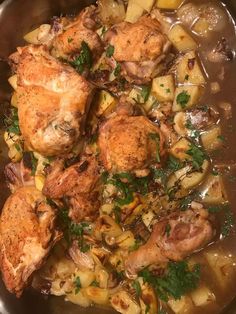 a pan filled with chicken, potatoes and parsley