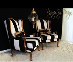 two black and white striped chairs sitting next to each other in front of a wall