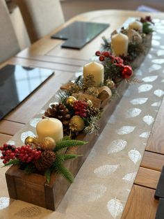 a long wooden table topped with candles and christmas decorations