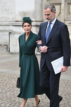 a man and woman walking down a cobblestone street