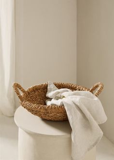 a wicker basket sitting on top of a white stool