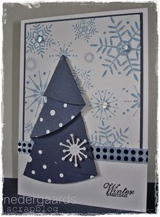 a handmade christmas card with a blue and white tree on the front, surrounded by snowflakes