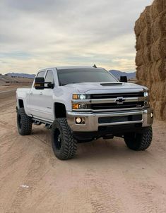 a large white truck parked on top of a dirt road