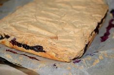 a piece of bread with blueberries on it sitting on top of some wax paper