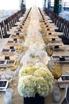 a long table with white flowers and wine glasses