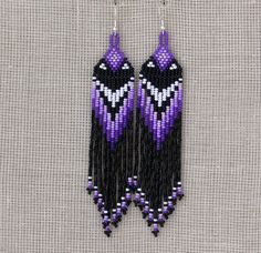 purple and black beaded earrings hanging from a hook