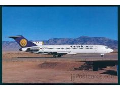 an alaska airlines plane is parked on the tarmac in front of mountains and sand