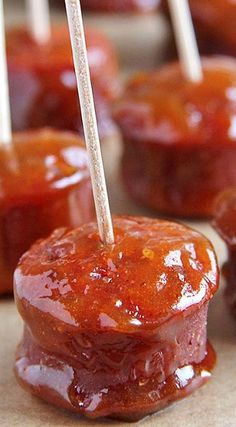 several small donuts covered in ketchup and toothpicks on a table