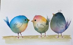 three little birds are standing on the edge of a piece of paper, one is blue and one is yellow