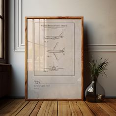 a framed poster with an airplane diagram on the wall next to a potted plant