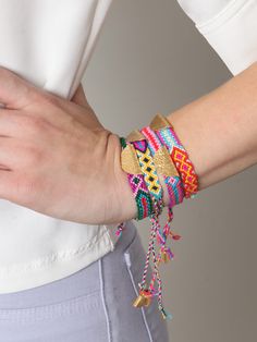 a woman wearing bracelets with tassels on her wrist