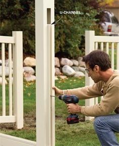 a man using a power drill to attach a fence post