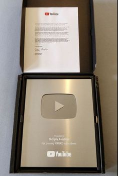 an open youtube box sitting on top of a table next to a paper and pen