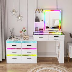 a white desk topped with a rainbow lit mirror next to a dresser filled with drawers