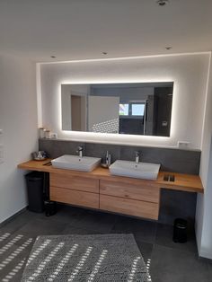 a bathroom with two sinks and a large mirror above it's counter top area