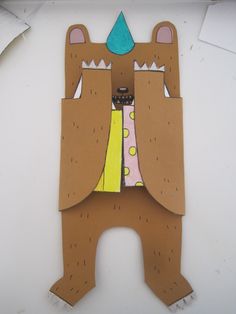 a paper cut out of a bear with a blue hat on it's head