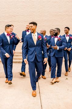 a group of men in suits walking down a sidewalk