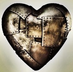 a heart shaped metal object with rivets on it