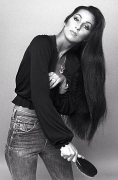 black and white photograph of a woman with long hair holding a brush in her hand