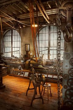 an old fashioned machine shop with lots of machinery in it's workshop area and large windows