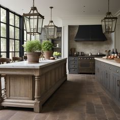 a large kitchen with an island in the middle and lots of lights hanging from the ceiling