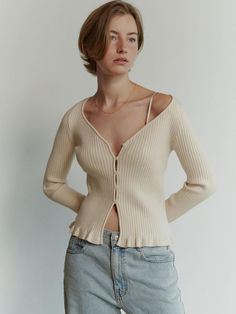 This Heart Neck Cardigan showcases a charming and feminine design that's perfect for layering. The heart-shaped neckline adds a unique and romantic touch, while the ribbed texture provides both comfort and fit. It's a versatile piece that can elevate a casual outfit or add a cozy element to a more dressed-up look. - Features a delicate button-down front which allows for easy wearing and adds subtle detail.- Constructed with a soft, stretchable fabric that hugs the body for a flattering fit.- The long sleeves and ribbed cuffs offer additional warmth and style.- This cardigan's cropped length pairs beautifully with high-waisted jeans or skirts. Feminine Fitted Cardigan For Layering, Fitted Feminine Cardigan, Feminine Fitted Sweater For Layering, Fitted Ribbed Beige Cardigan, Spring Cream Ribbed Cardigan, Feminine Fine Knit Winter Tops, Feminine Fitted Knit Top For Layering, Fitted Feminine Knit Top For Layering, Feminine Long Sleeve Ribbed Tops