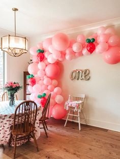 the balloon arch is decorated with pink and red balloons