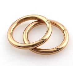 two gold colored rings sitting on top of each other