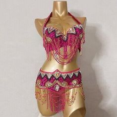 a mannequin wearing a pink and gold belly dance costume with chains on it