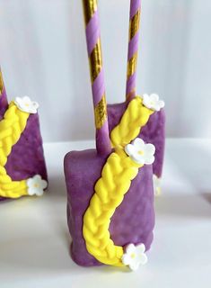 purple and yellow cake pops with flowers on them