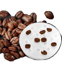 some coffee beans are next to a white plate