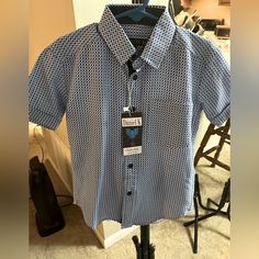 This Blue And White Shirt Is A Stylish Addition To Your Wardrobe. It Features A Collar, Button-Down Design And Short Sleeves. The Shirt Also Comes With A Color Front Chest Pocket, Adding A Touch Of Functionality And Style.Whether You're Dressing Up Or Staying A Casual. This Shirt Is A Versatile Choice That Will Keep You Looking Sharp And Comfortable. Blue Shirt With Snap Buttons For Summer, Blue Summer Shirt With Snap Buttons, Blue Short Sleeve Tops With Snap Buttons, Blue Short Sleeve Top With Snap Buttons, Blue Button-up Short Sleeve Shirt With Button Closure, Blue Button-up Short Sleeve Shirt With Placket, Blue Short Sleeve Button-up Shirt With Placket, Blue Short Sleeve Shirt With Buttons, Daniel K