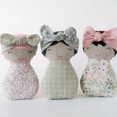 three little dolls with bows on their heads are sitting side by side in front of a white background