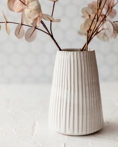 a white vase filled with flowers on top of a table