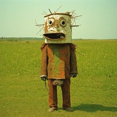 a strange looking robot standing in the middle of a field