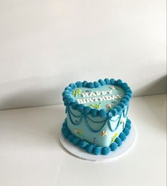 a blue birthday cake sitting on top of a white table