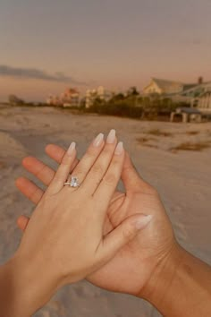 two hands holding each other on the beach