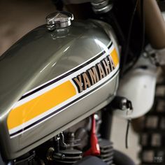 the front end of a motorcycle with yamaha written in yellow and white stripes on it