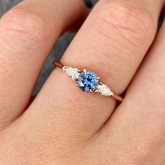 a woman's hand with a blue and white diamond ring