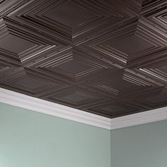 a bedroom with green walls and a ceiling made out of tin foils that looks like squares