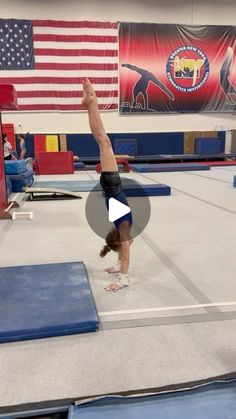 a person doing a handstand on a trampoline in front of an american flag